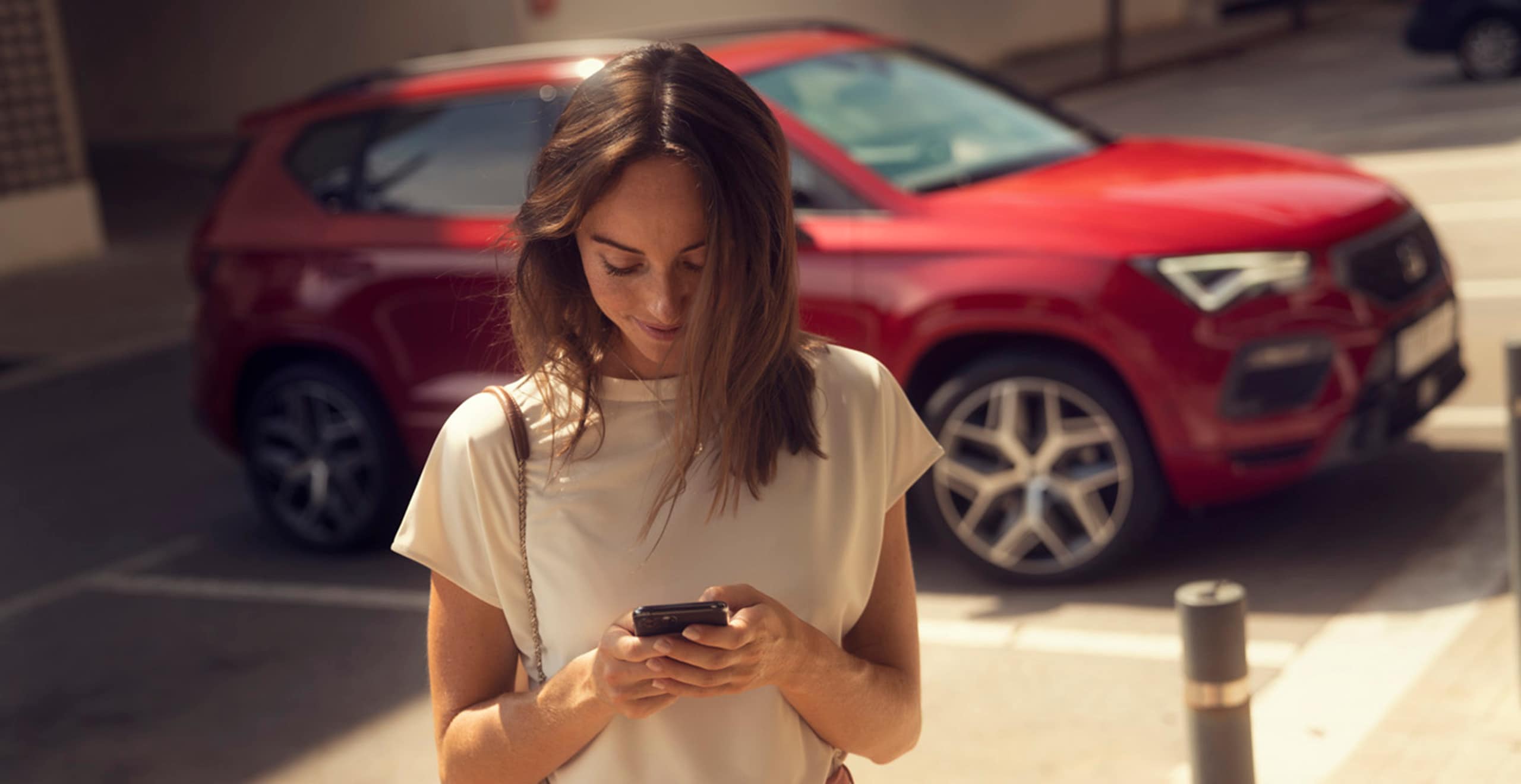 une femme avec son smartphone connecté à seat connect