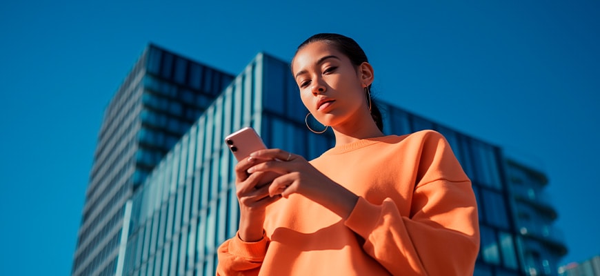 Une personne utilisant son smartphone pour montrer que vous pouvez télécharger les manuels où et quand bon vous semble.