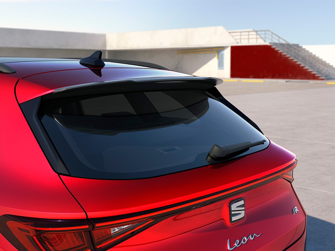 SEAT Leon rouge avec un becquet de toit sportif, améliorant l’aérodynamisme et les performances des finitions d’entrée de gamme ou avancées.