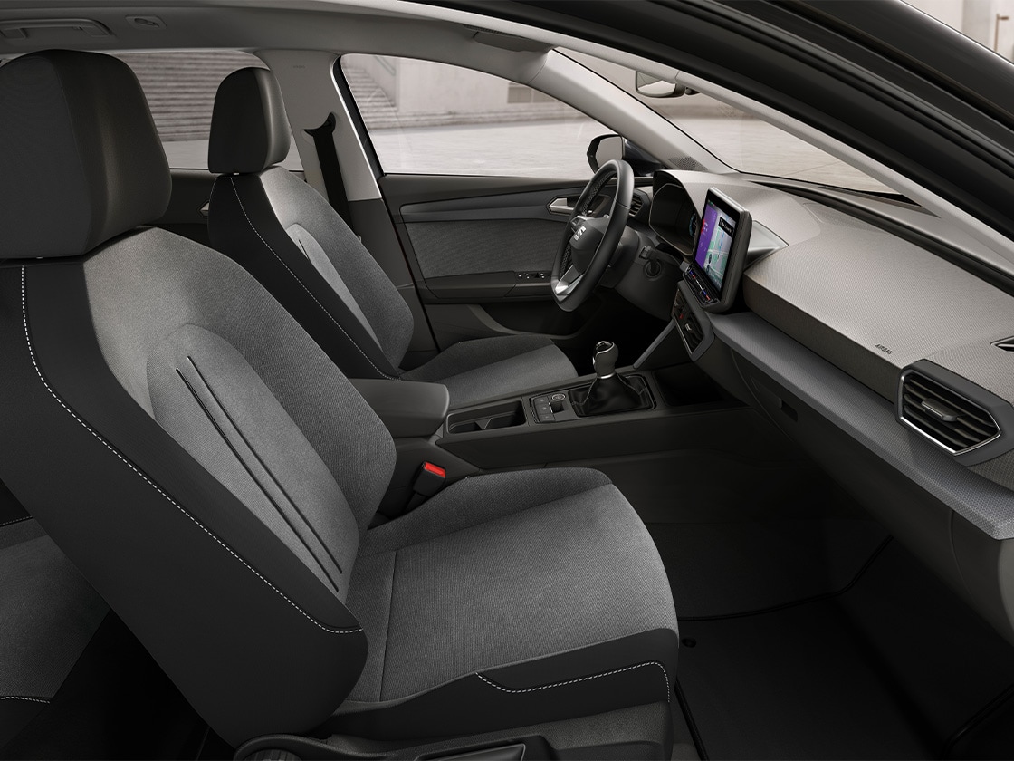 Vue intérieure de la SEAT Leon équipée de sièges confort en tissu, offrant une expérience de conduite détendue et pratique.