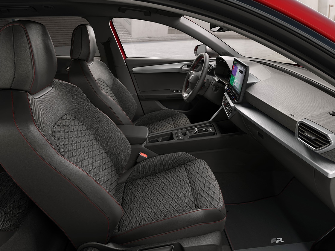 Vue intérieure de la SEAT Leon avec ses sièges confort en tissu FR, alliant soutien ergonomique et design élégant pour un voyage confortable.