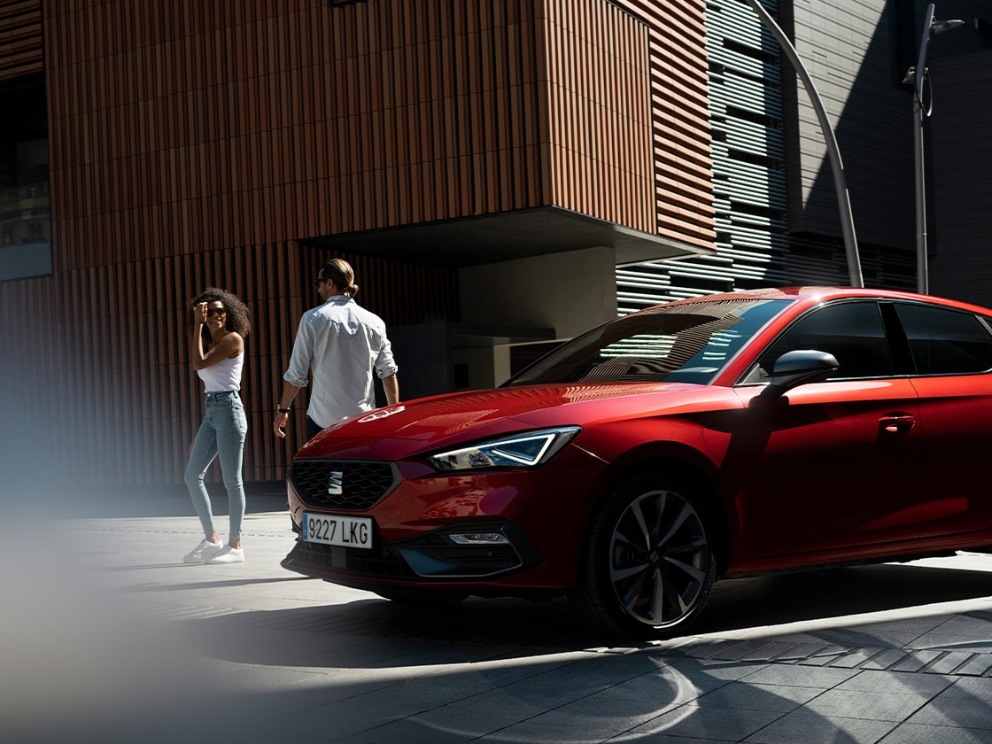 Seat leon rouge dans un cadre ensoleillé en plein air pour montrer que vous avez la possibilité de rester en sécurité et connecté où que vous alliez, grâce à seat connect.