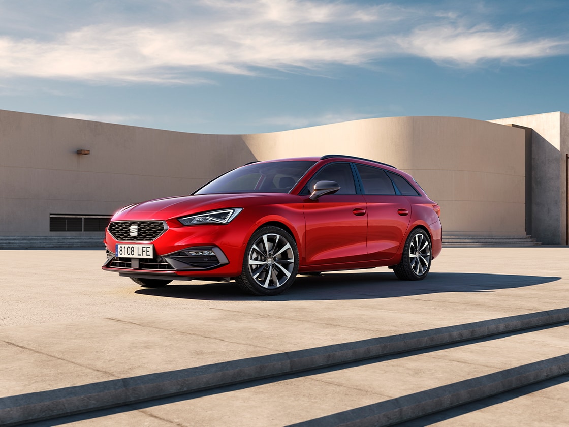La seat leon break fr avec ses jantes en alliage élégantes et son fascinant système drive profile. Le véhicule phare de la gamme seat est présenté sur fond de paysage extérieur.