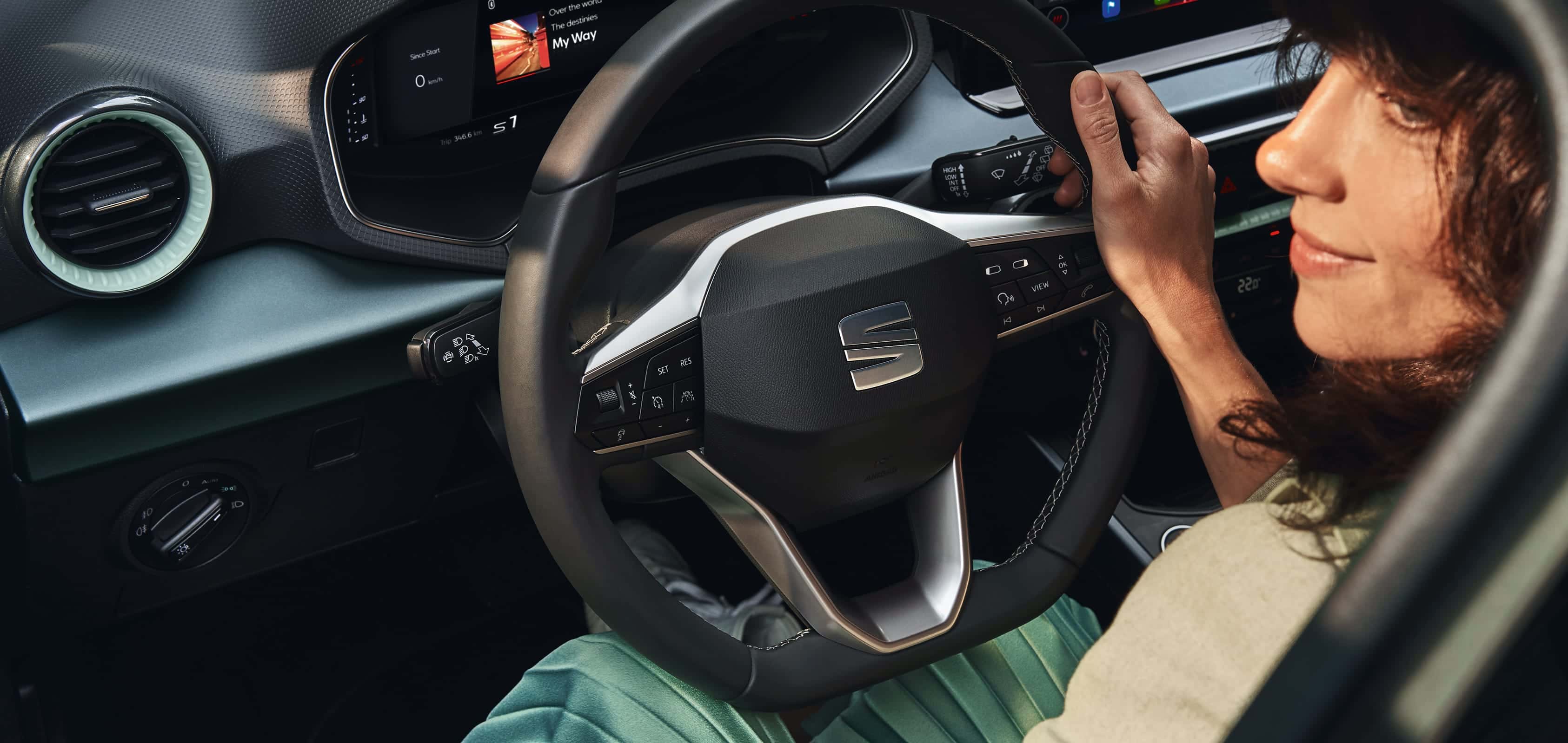 une femme s’éloignant d’une seat arona de couleur dark camouflage à toit blanc.