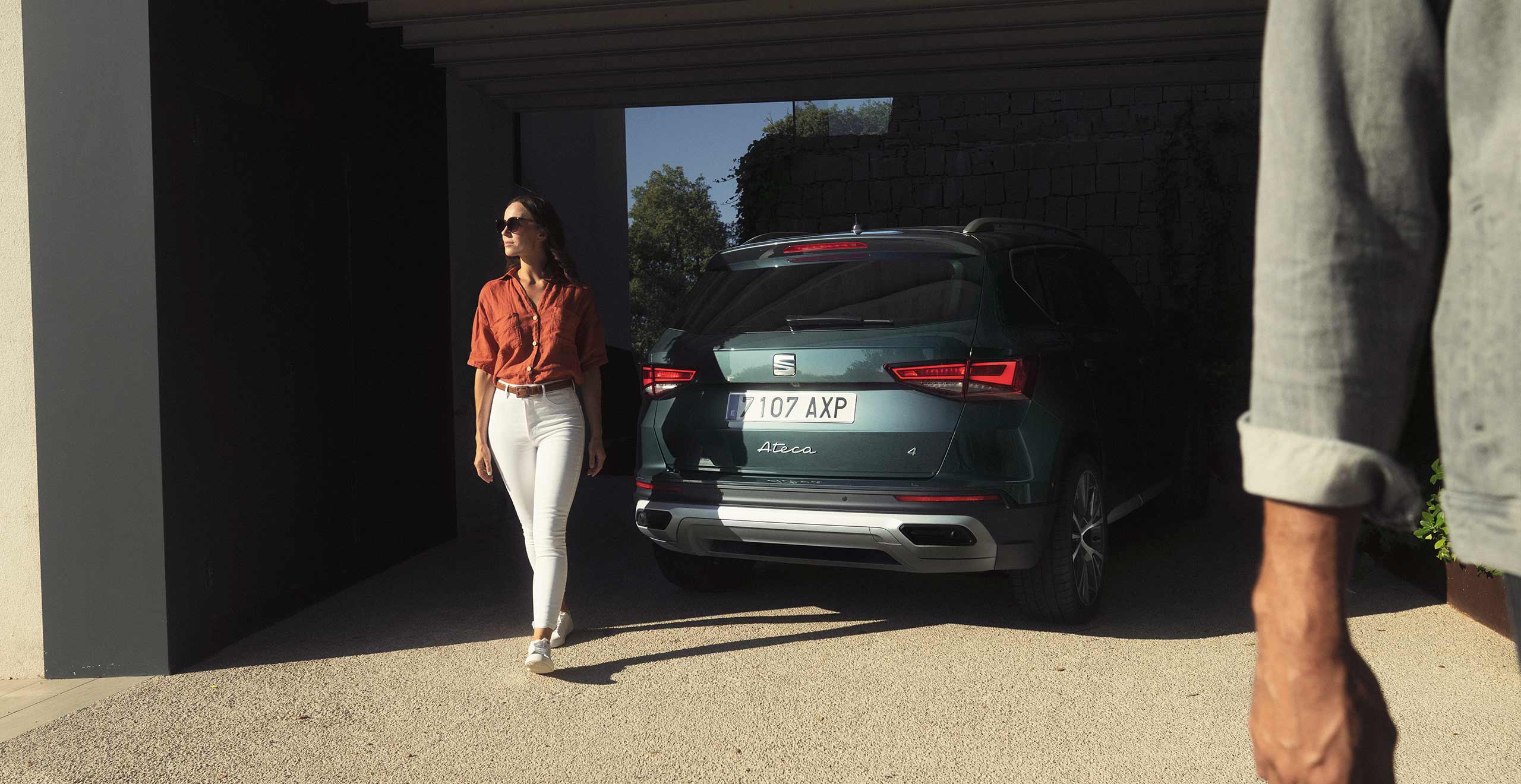 Woman standing next to the new SEAT Ateca dark camouflage with full rear led lights